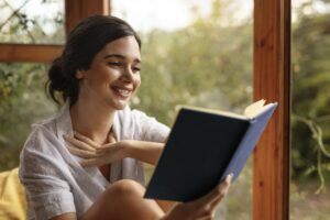 Mulher lendo livro que virou adaptação de série.